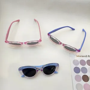 Kids gradient cat-eye sunglasses detail view showing colorful transparent frames and tinted lenses.