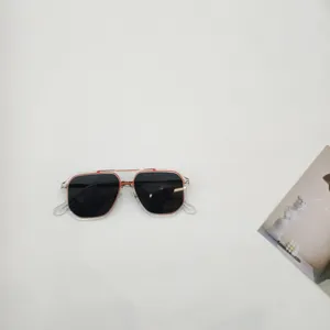 Primo piano dettagliato di occhiali da sole quadrati alla moda per bambini con dettagli arancioni.