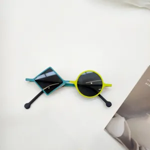 Nahaufnahme moderner asymmetrischer Kinder Sonnenbrillen mit geometrischen Rahmen.