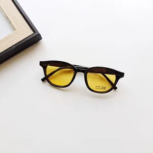 Kids fashion sunglasses with retro black frames and vibrant yellow lenses. UV400 protection.