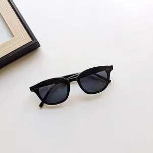 Detailed view of children's black fashion sunglasses with metal rivets on the square frame.