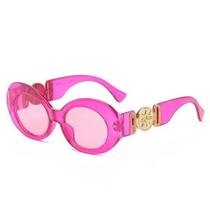Gafas de sol ovaladas oversize rosa de moda con medallón dorado elegante en las varillas.
