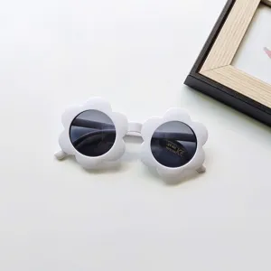 Detail shot of cute white flower sunglasses for kids, featuring UV400 dark protective lenses.