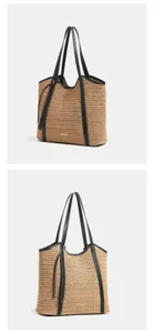 Gedetailleerd overzicht van de strovlecht tote bag met zwart lederen handvatten.