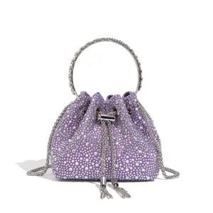 Detailaufnahme einer lila Strass-Beuteltasche mit Metall-Rundgriff und glitzernden Kristallen.