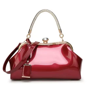 Detailed view of the elegant wine red glossy leather doctor bag with gold braided handle.