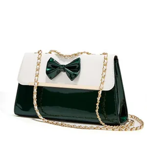 Detail view of the green and white patent leather bow chain shoulder bag closeup.