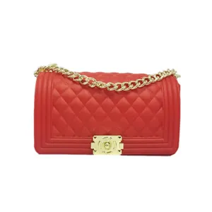 Detailed view of red quilted silicone shoulder bag featuring gold chain and metal clasp.