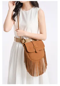 Close-up detail of the stylish brown faux-suede fringe crossbody bag worn by the model.