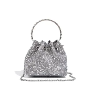 Nahaufnahme einer glitzernden Strass-Beuteltasche mit Metall-Rundgriff und Kettenriemen.