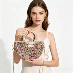 Detail view of the elegant rhinestone evening bag with beaded handle and metallic chain strap.