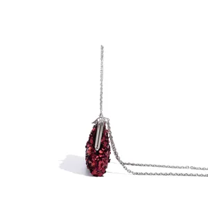 Red sequin evening bag detail, silver metal kiss-lock closure and slim chain strap side view.