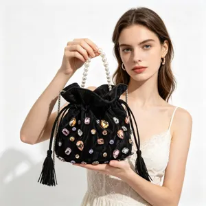 Black velvet bucket bag detail featuring faux pearl handle, colorful crystals and tassel drawstrings.