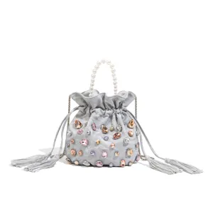 Silver rhinestone bucket bag with pearl handle, elegant drawstring pouch for women.