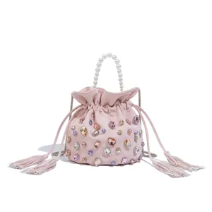 Detail view of the elegant pink crystal embellished bucket bag with a pearl handle.