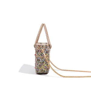 Detailed view of women evening bag with colorful rhinestones, pearl accents and gold chain.