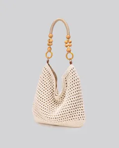 Handmade crochet cotton tote bag detail, featuring unique wooden bead handle and hollow design.