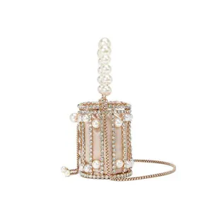 Elegant rhinestone caged evening bag with pearl handle, luxurious metallic cylinder clutch purse.
