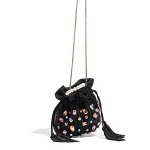 Black velvet bucket bag detail featuring pearl handle, sparkling rhinestones, and delicate chain.