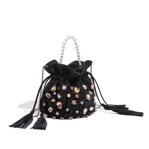 Black velvet bucket bag detail featuring pearl handle, colorful crystals and tassel string.
