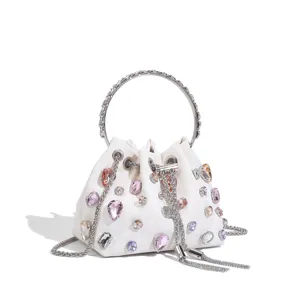 Détail élégant de sac seau en strass avec poignée anneau métal et cristaux brillants.