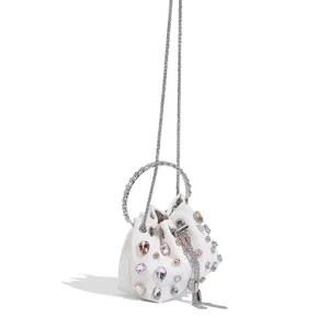 Vue detaillee du sac a main seau blanc scintillant avec des strass et poignee en metal.