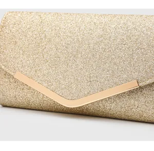 Gold glitter evening clutch bag detail showing elegant metallic V-bar clasp and shiny surface.