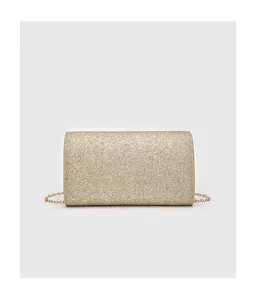 Close-up detail shot of the sparkling gold glitter evening bag with refined metal chain.