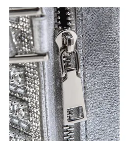 Silver rhinestone handbag metal zipper and glittering fabric detail macro close-up view.