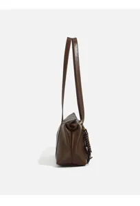 Side view detail of retro brown flocked leather women shoulder underarm bag with strap.