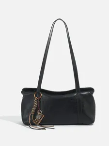 Black women's retro leather shoulder bag, minimalist underarm handbag with chic tassel charm.
