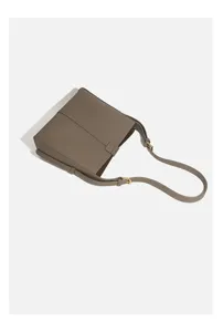 Detailed view of women's taupe shoulder bag, featuring fine textured leather and hardware detail.
