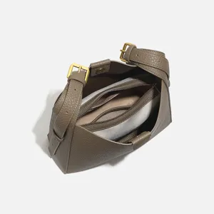 Grey leather shoulder bag with gold buckles and large capacity for women commuting.