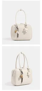 Bolso de hombro retro blanco para mujer con cierre de cremallera y encantadores colgantes.