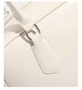 Vista detallada del bolso de mano retro en crema con textura de cuero y herrajes.