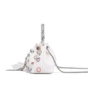 Sac seau blanc élégant orné de strass brillants et d'une poignée étincelante tendance.