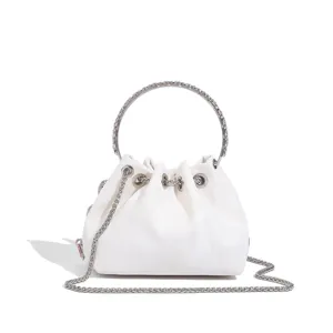 Gros plan détaillé du sac seau blanc avec poignée anneau métal et bandoulière chaîne.
