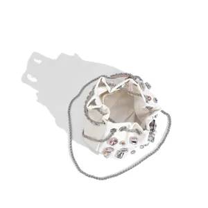 Détail de sac seau en satin blanc avec magnifiques strass scintillants et chaîne métal.