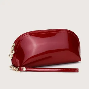 Red patent leather shell cosmetic makeup bag with gold hardware heart charm and wrist strap