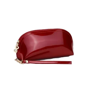 Red patent leather shell cosmetic bag for women, trendy clutch purse with wrist strap.