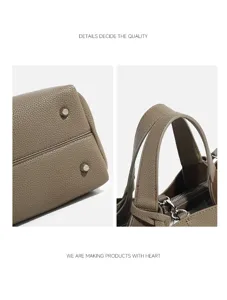 Detailed view of women's leather handbag showing bottom metal studs and handle craftsmanship.