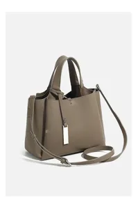 Detail view of the elegant pebble grain leather crossbody tote bag with sleek metal pendant
