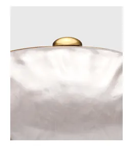 Dettaglio borsa pochette in acrilico con trama marmo e chiusura metallica dorata.
