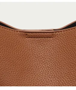 Premium brown pebbled leather texture detail of women's fashion shoulder bag with fine stitching.