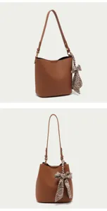 Brown bucket bag detail showing textured leather and elegant patterned scarf accessory.