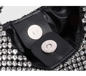 Black rhinestone bucket bag detail showing sparkling crystals and magnetic snap closure.