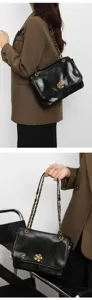 Classic black leather shoulder bag featuring chic gold chain strap and flower clasp.