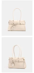 Trendy women's PU leather shoulder handbag featuring a chic buckle strap and heart charm.