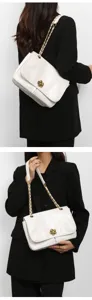 Elegant white chain shoulder bag for women, chic commuter crossbody bag with floral lock.