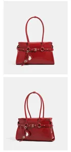 Close-up details of red patent leather shoulder handbag, stylish buckle strap and heart charm.